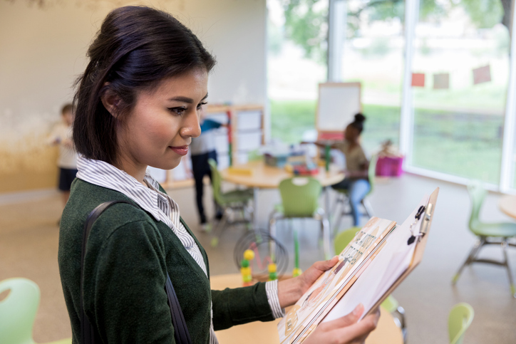 A woman looking at a clipboard.