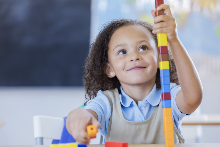 a child stacks colorful blocks