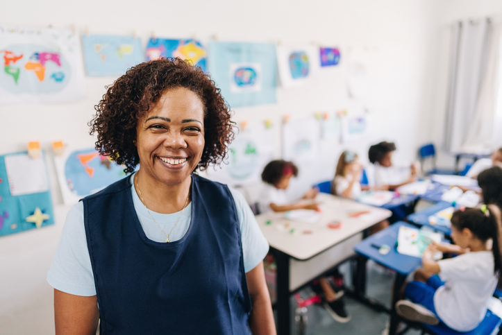 a caregiver in a program with children at desks